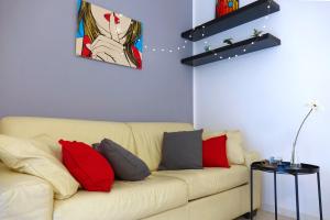 ein Wohnzimmer mit einem Sofa mit roten und grauen Kissen in der Unterkunft Metro Bengasi Torino Lingotto Premium location - eXpress traveler spazioso - Grand Maison in Turin