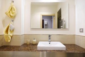 ein Badezimmer mit einem weißen Waschbecken und einem Spiegel in der Unterkunft Metro Bengasi Torino Lingotto Premium location - eXpress traveler spazioso - Grand Maison in Turin