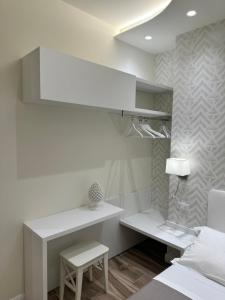 a white bedroom with a bed and a desk at Ines bed and breakfast & Apartments in Giardini Naxos