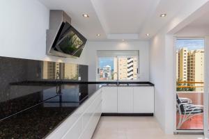 a kitchen with a black and white counter top at The White Apartment: Luxury, Beach and Design in Valencia