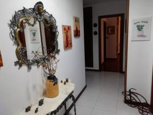 a mirror on a wall next to a table with a vase at Piso Vacacional Carballeira in O Grove