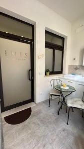 Zimmer mit einem Tisch, 2 Stühlen und einer Theke in der Unterkunft Ines bed and breakfast & Apartments in Giardini-Naxos