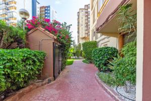 Una pasarela de ladrillo con flores en el lateral de un edificio en The White Apartment: Luxury, Beach and Design, en Valencia