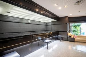 a waiting room with benches and tables in a building at Court Hotel Niigata in Niigata