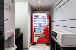 a red vending machine in a room with a microwave at Court Hotel Niigata in Niigata