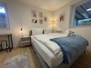 Un dormitorio con una cama con un osito de peluche. en Vorstadtoase - Apartment für 2 Personen mit Smart TV, Parken, eigenen Bad, Netflix - Nähe BER en Eichwalde