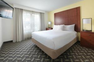 a hotel room with a large bed and a flat screen tv at Residence Inn Dallas Addison/Quorum Drive in Dallas