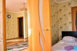 Schlafzimmer mit orangefarbener Tür und einem Bett in der Unterkunft Нью-Йорк in Petropawlowsk