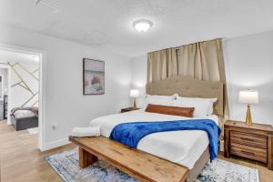 - une chambre avec un grand lit et un banc en bois dans l'établissement Estelo's Place - Modern townhouse with King bed, only 5 min from the Airport!, à Miami