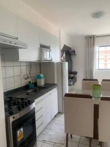 uma cozinha com armários brancos e um forno com placa de fogão em Excelente FLAT/PRAIA PINA no Recife