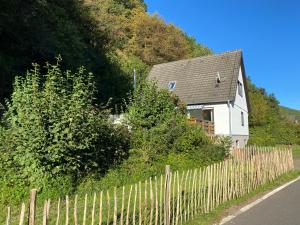 una casa blanca con una valla al lado de una carretera en Ferienhaus Sönnchen, en Schleiden
