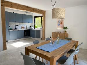 uma cozinha e sala de jantar com uma mesa de madeira e cadeiras em Ferienhaus Sönnchen em Schleiden