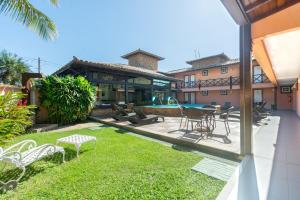 a patio with chairs and a table in a yard at Pousada Marbella Inn in Búzios