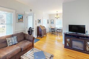 a living room with a couch and a flat screen tv at Coastal Joy in Hall Quarry