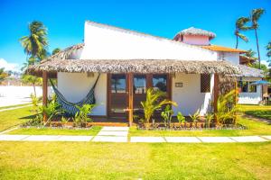 uma casa na praia com telhado de palha em Rancharia Charme Beach - Pé na Areia em Atins