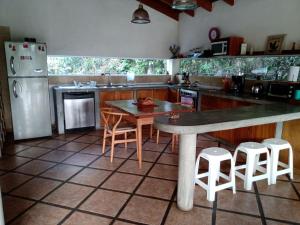 cocina con mesa, sillas y nevera en Casa El Palto, en Santa Eulalia