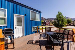 um deque com cadeiras e uma mesa em frente a um edifício azul em Dana Blue em Apple Valley