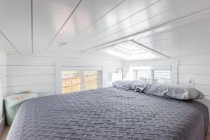 a bedroom with a large bed in a white room at Zion Tiny Home, Hot Tub, Gooseberry Mesa Trails in Apple Valley