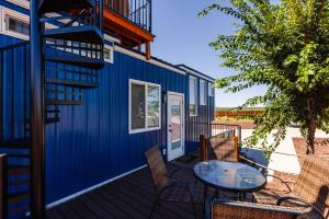 a blue house with a table and chairs on a deck at Lil' Blue Oasis Tiny Home in Apple Valley