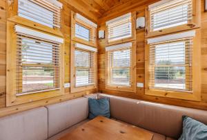 a room with a couch and windows in a log cabin at Couples Escape Near Zion, Pet Friendly in Apple Valley +14 photos