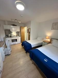 um quarto de hotel com duas camas e uma cozinha em The Tas Suites - Tas Accommodations em Cambridge