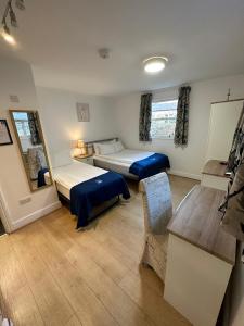 Zimmer mit 2 Betten und einem Tisch in der Unterkunft The Tas Suites - Tas Accommodations in Cambridge