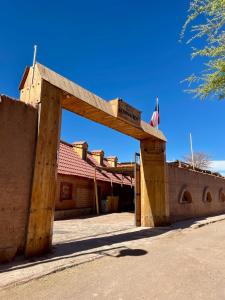 una entrada a un edificio con un cartel en él en Hotel Corvatsch, en San Pedro de Atacama