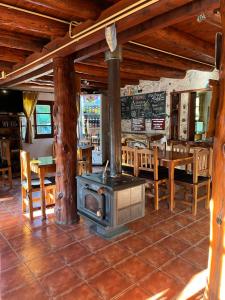 a wood stove in a restaurant with a table at Hostel El Mirador in El Bolsón