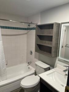 een badkamer met een toilet, een bad en een wastafel bij Days Inn & Suites by Wyndham Summerside in Summerside