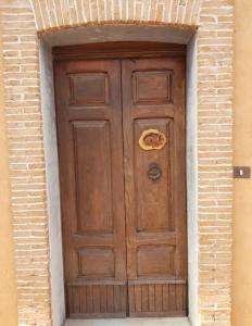 una gran puerta de madera en un edificio de ladrillo en B&B La Rocca, en San Nicola Manfredi