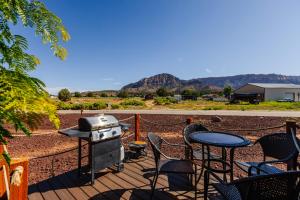a grill on a deck with chairs and a table at Royal sands tiny home in Apple Valley