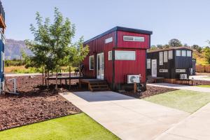Una casetta rossa e nera in un giardino di Ruby Red Tiny Home a Apple Valley