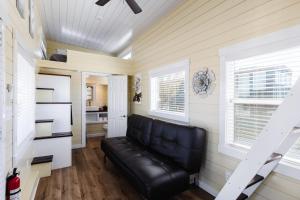 divano in pelle nera in una camera con cucina di Ruby Red Tiny Home a Apple Valley