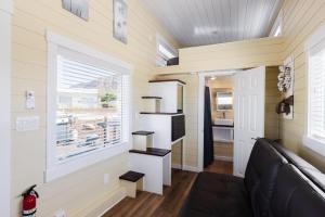 Ruby Red Tiny Home في Apple Valley: غرفة معيشة مع أريكة ونافذة
