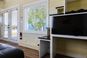 uma sala de estar com uma grande televisão de ecrã plano em Ruby Red Tiny Home em Apple Valley