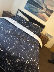 a bed with a black comforter with stars at Unparalleled convenience! Luxury in Manchester