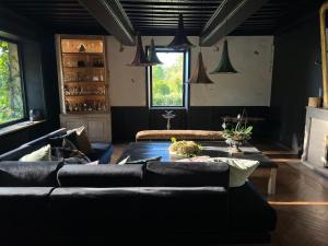 ein Wohnzimmer mit einem Sofa und einem Tisch in der Unterkunft chambre d'hôtes Madame in Branges