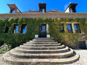 a set of stairs in front of a building with ivy at chambre d'hôtes Madame in Branges