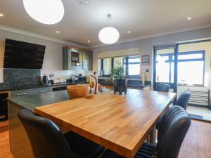 a kitchen and dining room with a wooden table and chairs at Beach Haven in Norwich