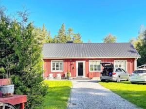 ein rotes Haus mit einem davor geparkt in der Unterkunft Holiday home SVENLJUNGA in Tranemo