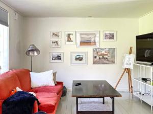 ein Wohnzimmer mit einem roten Sofa und einem Tisch in der Unterkunft Holiday home SVENLJUNGA in Tranemo