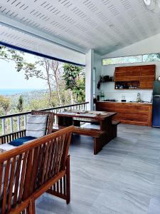 恰洛克拉姆的住宿－Villa Ashiana - Jungle Seaview，阳台的用餐室配有桌子和长凳