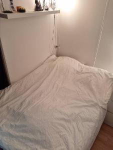 - un lit blanc dans une chambre dotée d'un mur blanc dans l'établissement T 3 Paris-Orly aéroport 10 min • jardin parking, à Athis-Mons
