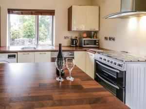 a kitchen with a bottle of wine and two glasses on a counter at Shore Road in Culdaff