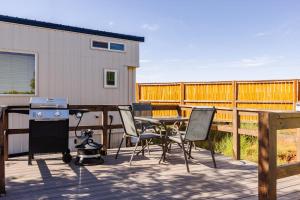 a patio with a table and chairs and a grill at Moonrise Tiny Home in Apple Valley