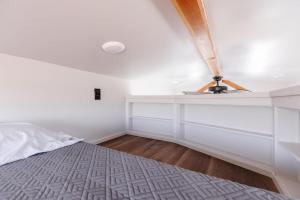 a bedroom with a bed and a white wall at Moonrise Tiny Home in Apple Valley