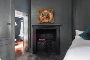 a room with a fireplace with a picture on the wall at Welcome London Soho in London +10 photos