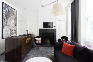 een woonkamer met een bank en een open haard bij Welcome London Soho in Londen
