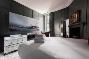 een slaapkamer met een bed en een tv aan de muur bij Welcome London Soho in Londen