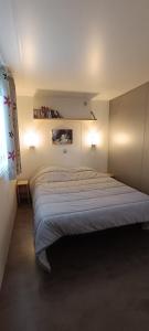um quarto com uma cama grande num quarto em Oléron Mobil home climatisé tout confort 50 m de l'océan em La Bétaudière